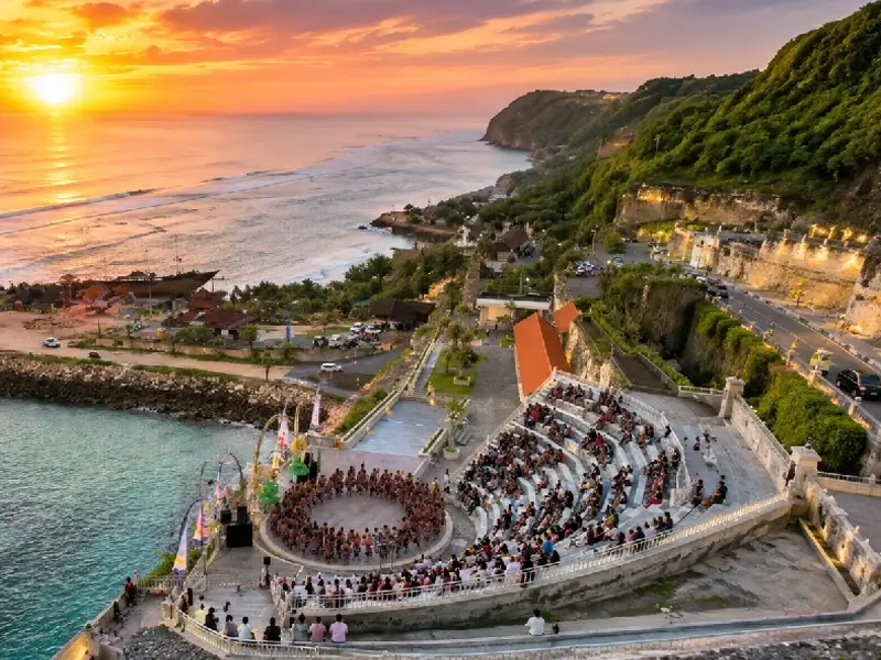 Sunset Pantai Melasti Bali dengan amphitheater, pertunjukan tari Kecak, tebing hijau, dan panorama laut