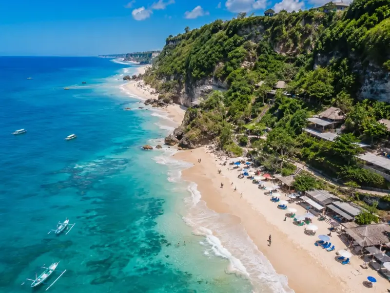 Pemandangan Pantai Pandawa Bali dari atas dengan pasir putih, laut biru, dan tebing hijau di sekitarnya
